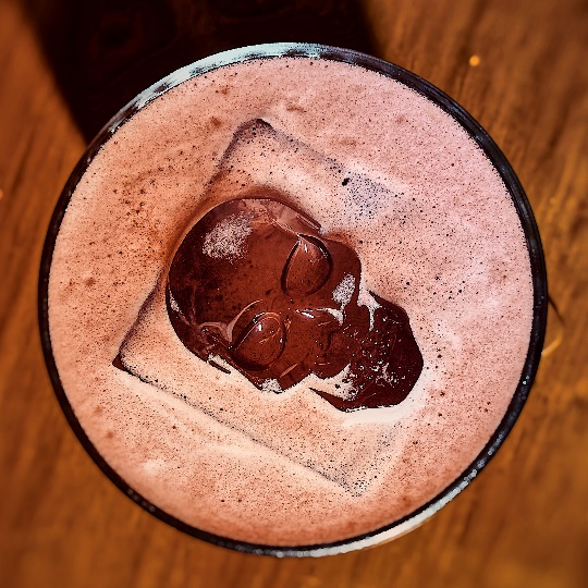 A glass of liquid with a skull in it Description automatically generated